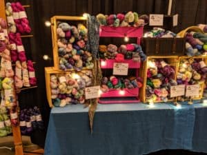 Hand dyed yarn in crates on a table at a fiber festival
